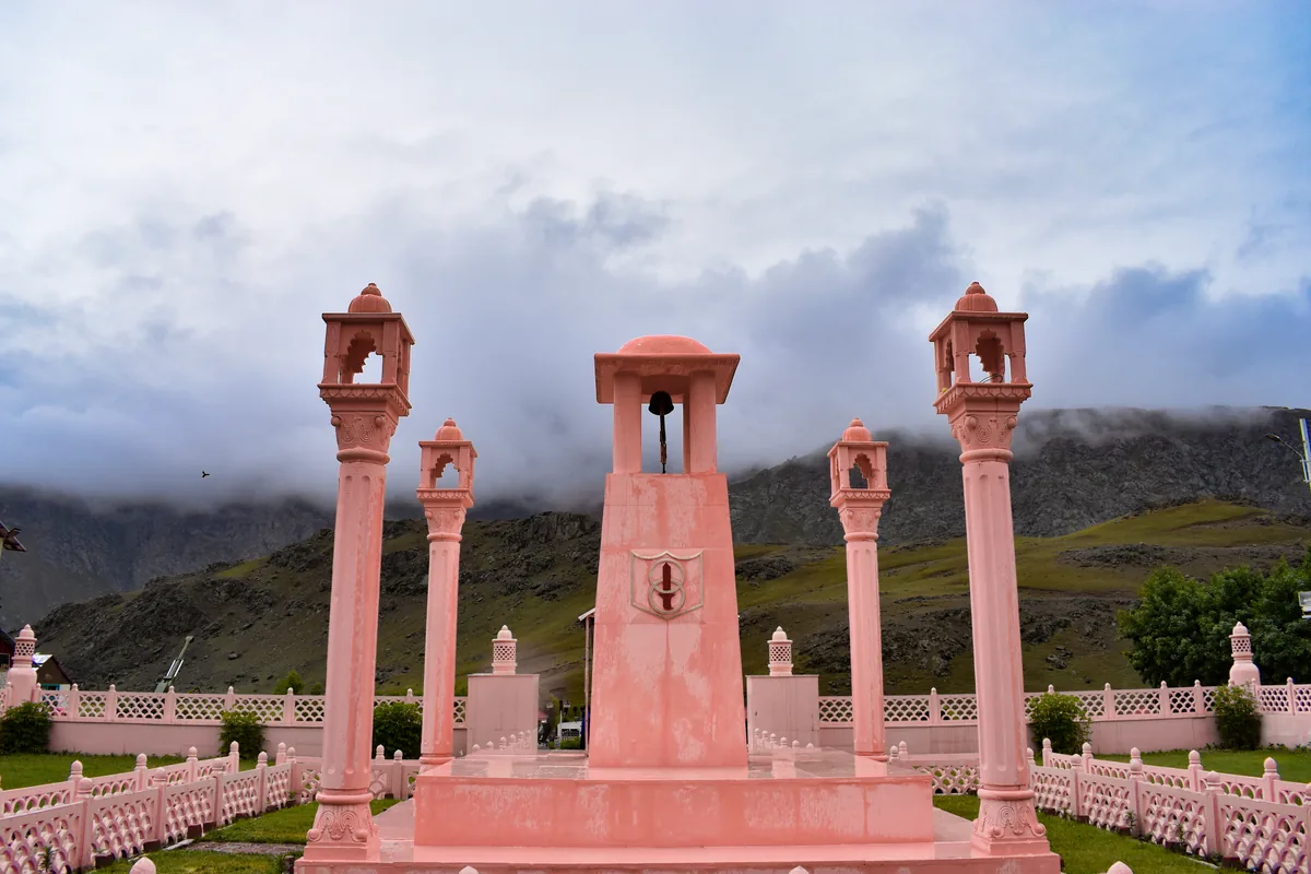 Drass Kargil War Memorial pink sandstone Wall of Heroes beneath Tololing peak on NH1