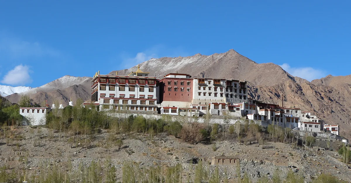 Whitewashed complex of Phyang Monastery nestled against the Blue Mountain in the Indus Valley