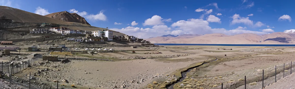 Whitewashed houses of Korzok village overlooking the turquoise waters of Tso Moriri lake in Ladakh