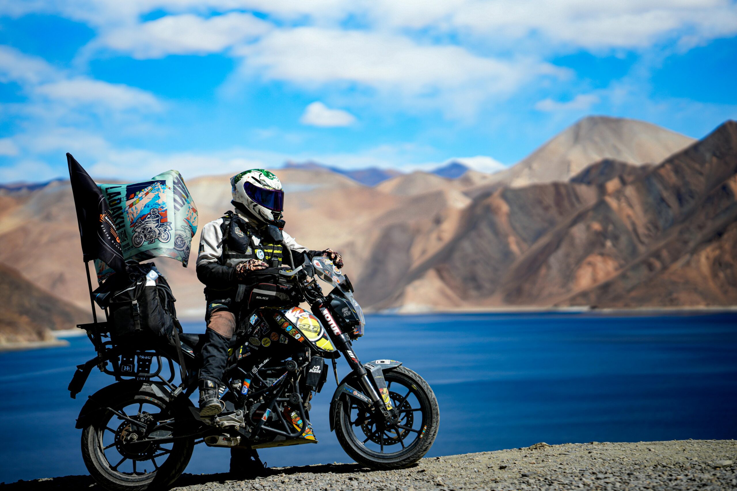 adventurous biker during leh ladakh bike tour by pangong lake in ladakh
